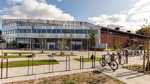 Område utenfor bygg med steinheller og sykkelstativ